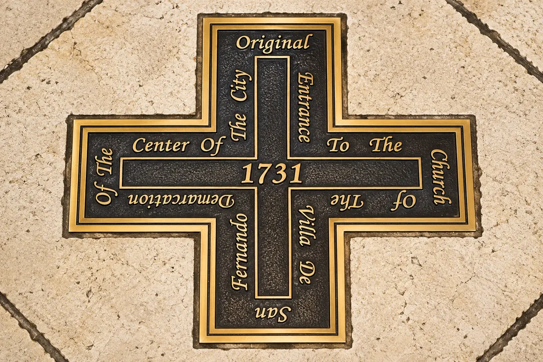 A bronze cross set into the cathedral floor reading: Original Entrance To The Church Of The Villa De San Fernando, Center Of The City, Demarcation Of The 1731.